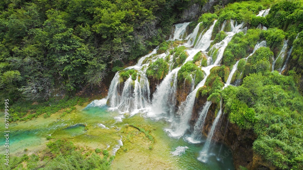 Obraz premium Beautiful waterfalls in summer National Park. Scenic mountain streams flow into a lake with aquamarine clear water. Summer landscape.