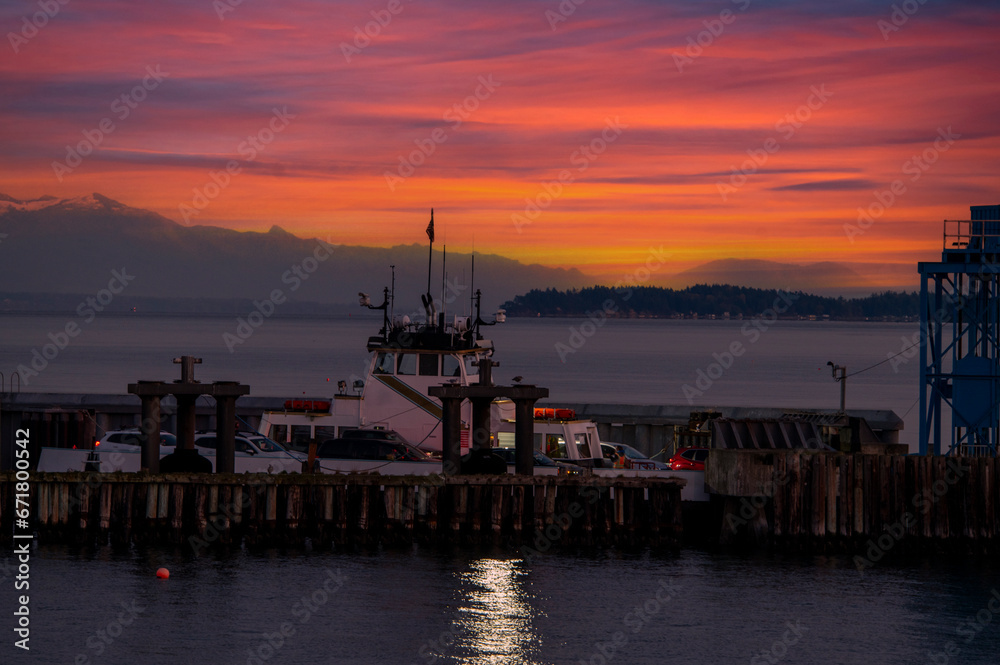 Ferry boat docking at an island in the Salish Sea during a dramatic sunrise. The Whatcom Chief services Lummi Island commuters traveling to the mainland. Washington, USA