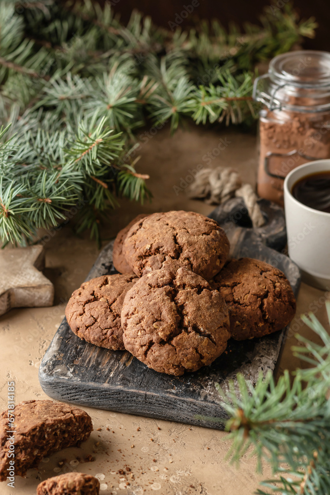 Fototapeta premium Homemade christmas chocolate cookies on wooden board and coffee on brown festive background with fir tree branches. Christmas holiday desserts