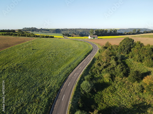 Aerial view of a curved road in the landscape on a sunny morning in summer