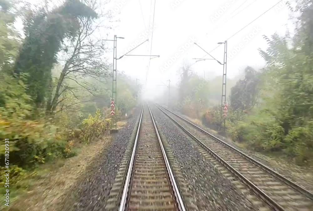 Front view or driver cabin view of a train travelling on tracks in the city with autumn trees during fall Front view or driver cabin view of a train travelling on tracks in the city with autumn trees during fall