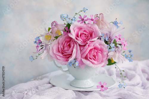 Bouquet of spring and summer flowers in a cup on the table   rose  aquilegia  forget me not flowers  beautiful postcard  still life  blur.