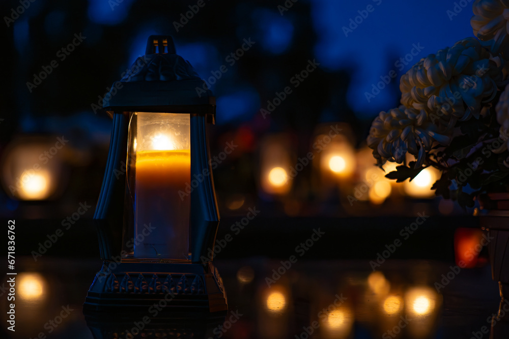 Candle light in the cemetery at night. Selective focus.All saint's day.  Lanterns in the cemetery at night.Lantern on the background of burning candles in the night.