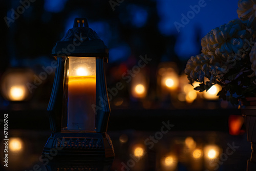 Candle light in the cemetery at night. Selective focus.All saint's day. Lanterns in the cemetery at night.Lantern on the background of burning candles in the night.