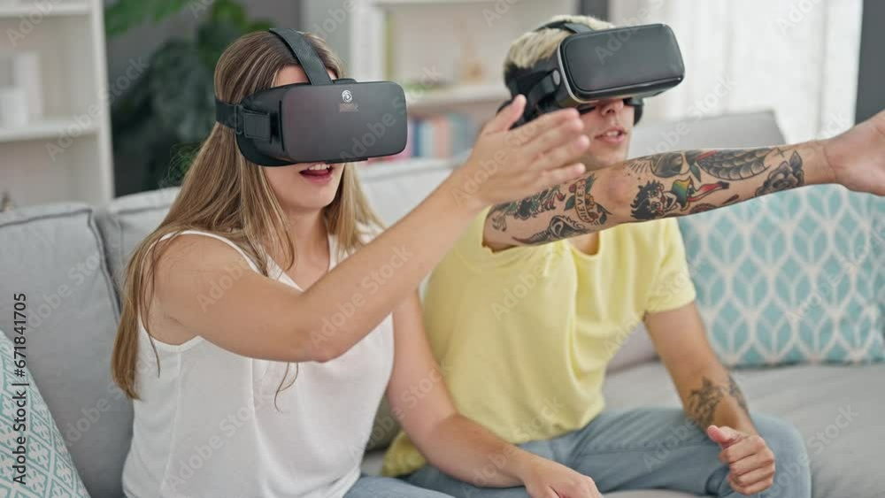 Beautiful couple playing video game using virtual reality glasses at home