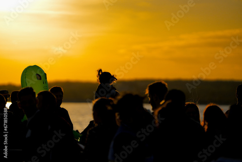 young people on the shore of a lake at sunset.