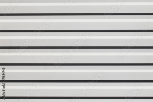 Corrugated metal sheet background. White paint metal stripes. Striped pattern. Garage door. Geometric lines metal wall.