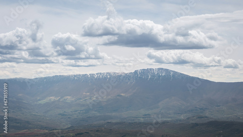 View of a snow covered Suva planina (Dry mountain) ridge and Trem summit under a hazy sky