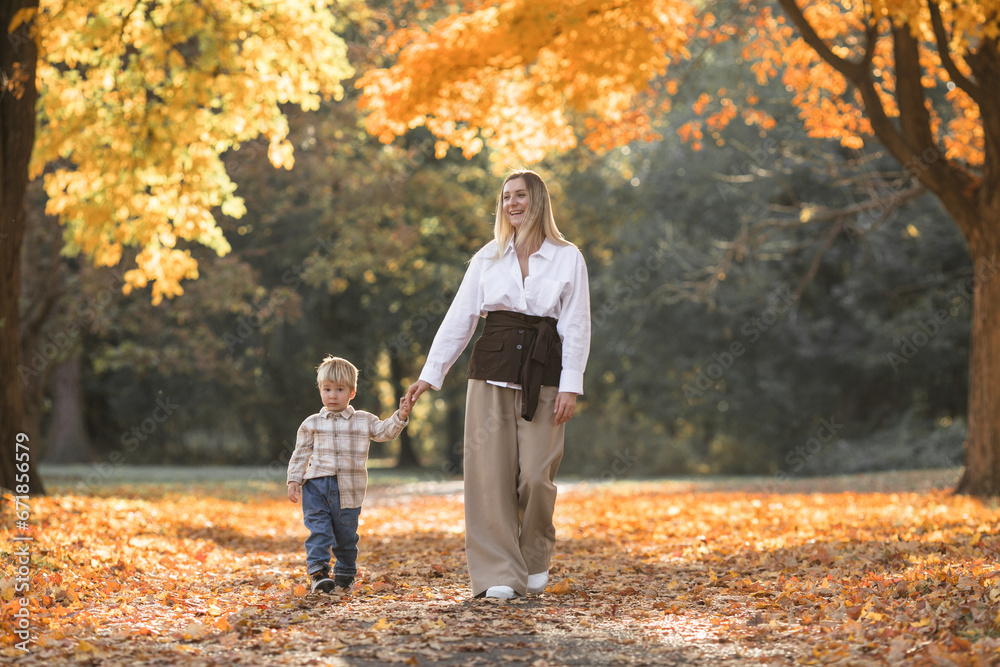 Fototapeta premium Mothers day, love family. Family on autumn walk in nature outdoors. Mother and child with hugging tenderness