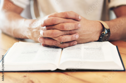 Religion, reading and hands of a man with a bible for prayer, worship and hope. God, christian and spiritual person with belief in Jesus, looking for support and help from a religious book on a table