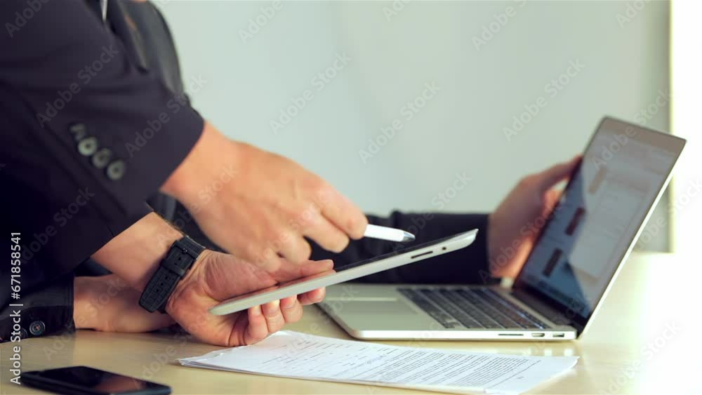 Young businessman showing a business plan on the tablet its companion Young businessman showing a business plan on the tablet its companion