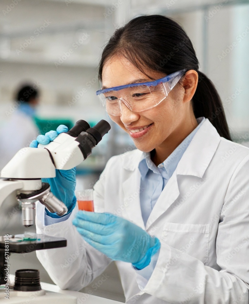 Female korean scientist working with microscope at laboratory Female korean scientist working with microscope at laboratory