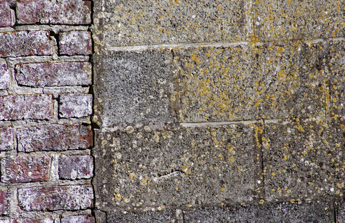 Mur z pustaków betonowych połączony z cegłami.