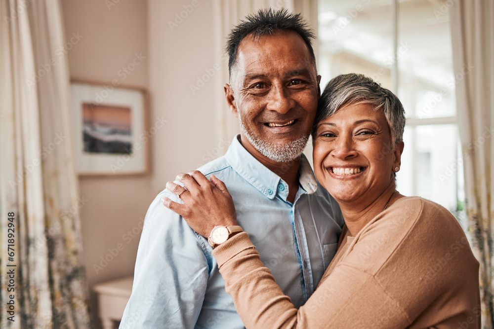Portrait, happy and senior couple in home living room for bonding together. Face, elderly man and Indian woman in lounge to smile for quality time, hug for support and embrace for love in retirement
