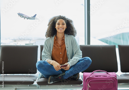 Airport, black woman and portrait of a young person at flight terminal waiting for airplane travel. Passport document, smile and sitting solo female traveler feeling happy with freedom from adventure photo
