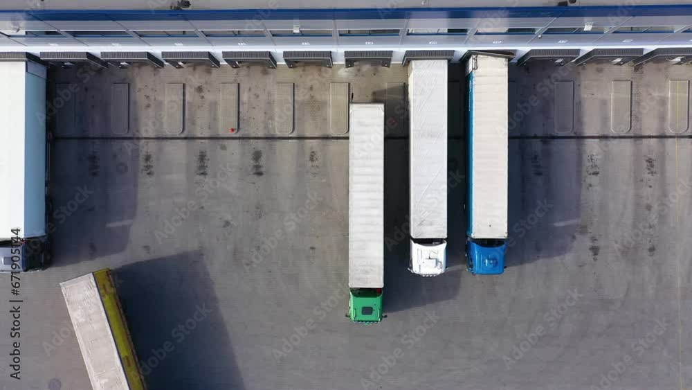Aerial Shot of Truck with Attached Semi Trailer Leaving Industrial Warehouse/ Storage Building/ Loading Area where Many Trucks Are Loading/ Unloading Merchandise. Shot on Phantom 4K UHD Camera. Aerial Shot of Truck with Attached Semi Trailer Leaving Industrial Warehouse/ Storage Building/ Loading Area where Many Trucks Are Loading/ Unloading Merchandise. Shot on Phantom 4K UHD Camera.