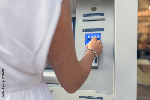 Woman insert credit card to atm