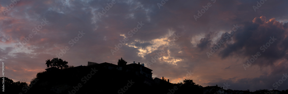 Colorful sunset over the Bulgarian town of Balchik. Cumulus clouds in a red-purple scale.