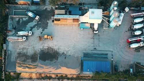 Aerial view of a semi trucks with cargo trailers standing on warehouses ramps for loading/unloading goods on the big logistics park with loading hub photo