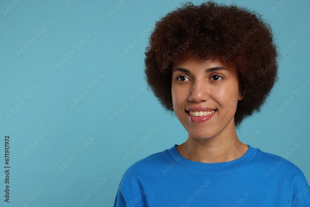 Portrait of happy young woman on light blue background. Space for text Portrait of happy young woman on light blue background. Space for text