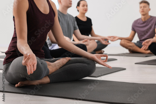 Group of people practicing yoga on mats indoors, closeup