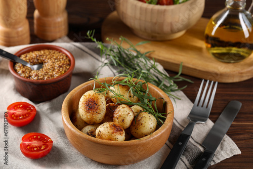 Delicious grilled potatoes with tarragon and mustard on wooden table