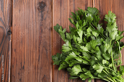 Bunch of fresh green parsley leaves on wooden table, top view. Space for text
