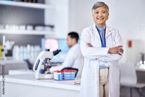 Portrait, research and senior woman with arms crossed, medical and scientist with lab equipment, smile and growth. Female person, confidence and healthcare professional with science and innovation photo