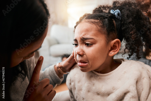 Discipline, angry and mother with girl, home and unhappy with expression, crying and naughty. Serious, female child and mama with conflict, sad and conversation with reprimand, punish kid and advice photo