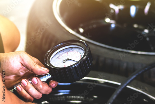 Mechanic using a pressure gauge to measure the pressure of the car. photo