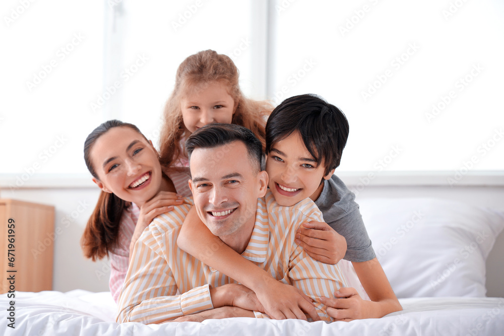 Little children with their parents hugging in bedroom