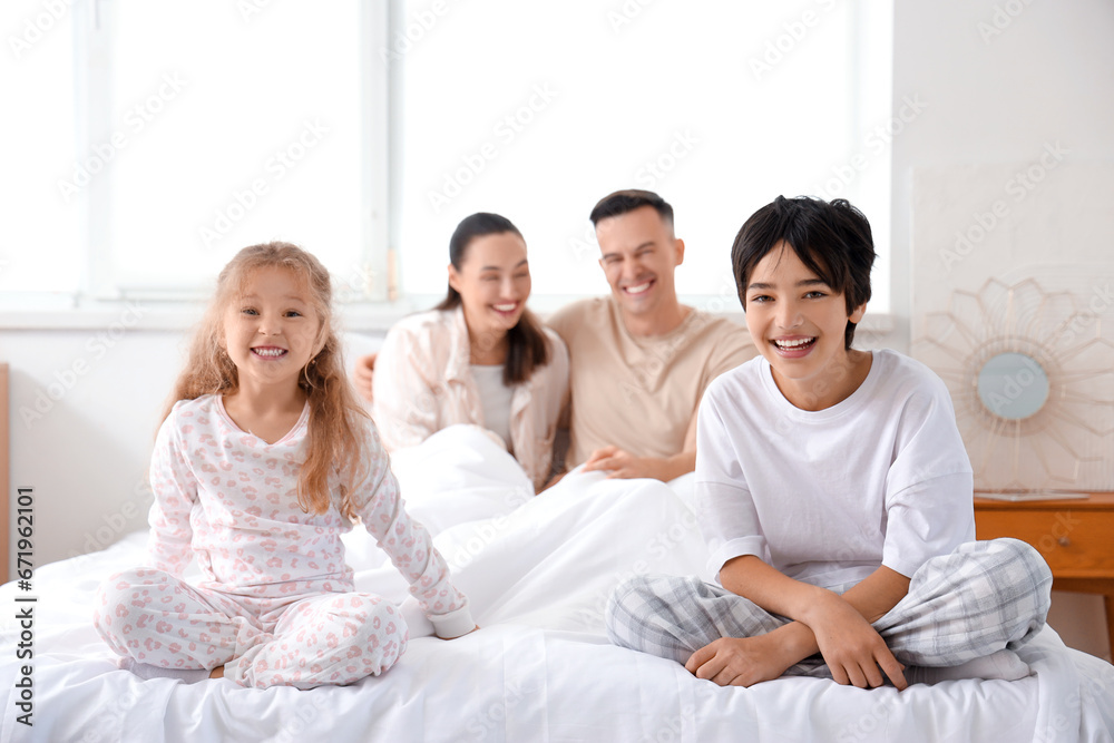 Happy little children with their parents in bedroom Happy little children with their parents in bedroom