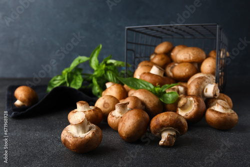 Basket with fresh mushrooms and basil on black background