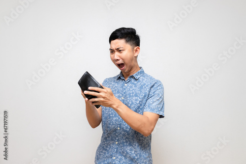 Poor man blue shirt feels shock about looking at empty wallet in his hand isolated