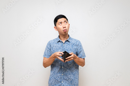 Asian poor man blue shirt holding empty wallet feels worried about no money isolated