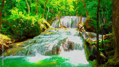 Waterfalls and fish swim in the emerald blue water in Erawan National Park. Erawan Waterfall is a beautiful natural rock waterfall in Kanchanaburi, Thailand.Onsen atmosphere