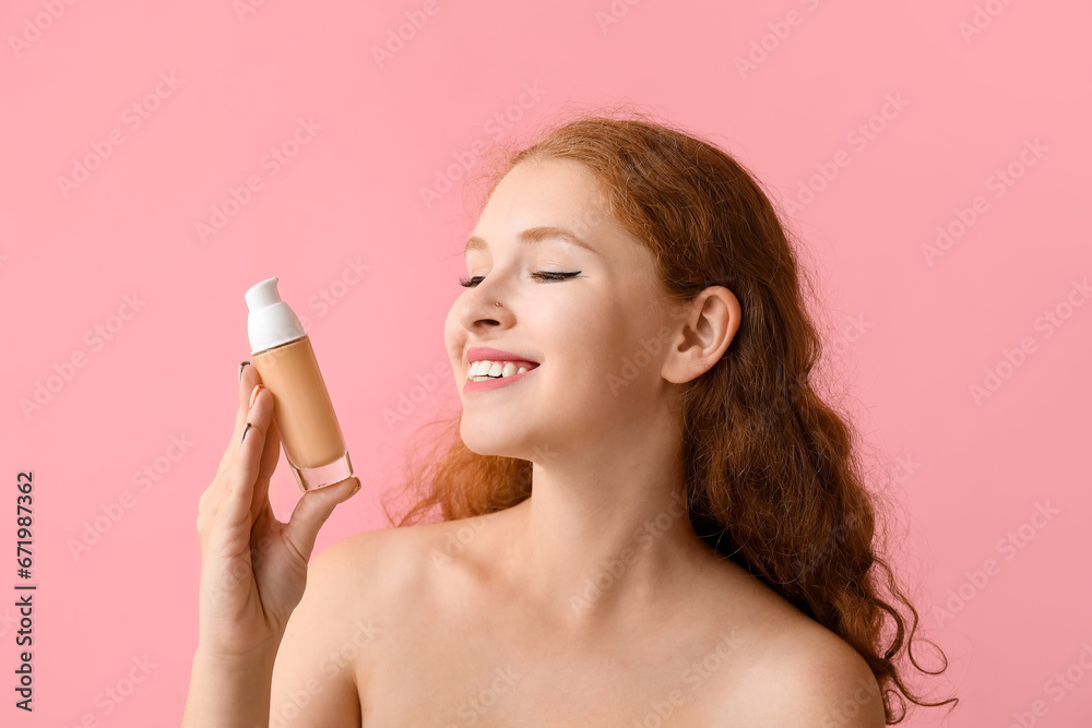 Young redhead woman with makeup foundation on pink background, closeup Young redhead woman with makeup foundation on pink background, closeup