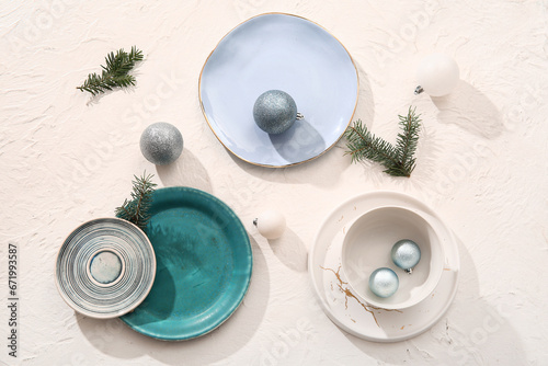 Beautiful table setting with Christmas balls and fir branches on white background