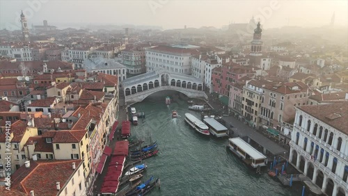 Drone footage flying over Venice, Italy during a morning sunrise. Clear 4K view of the Rialto Bridge, as well as the beautiful architecture of the ancient town, which is a UNESCO heritage site.