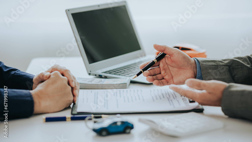 Close up of Asian man's car insurance document or rental agreement or agreement Trading with car keys on the table Making a contract for buying or renting a car
