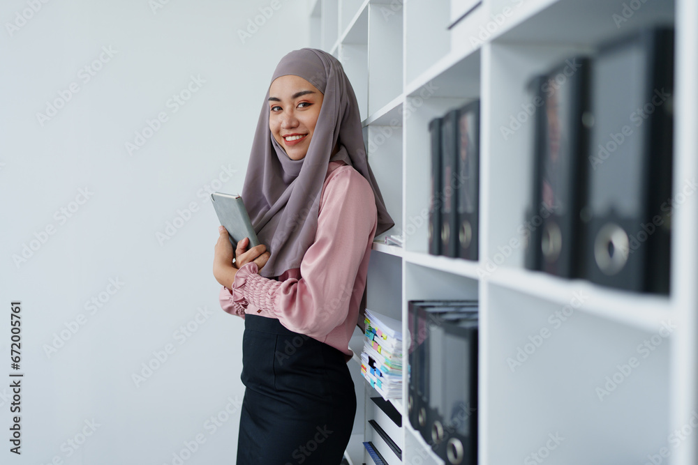 Muslim female employee Searching for documents in the office. Muslim female employee Searching for documents in the office.