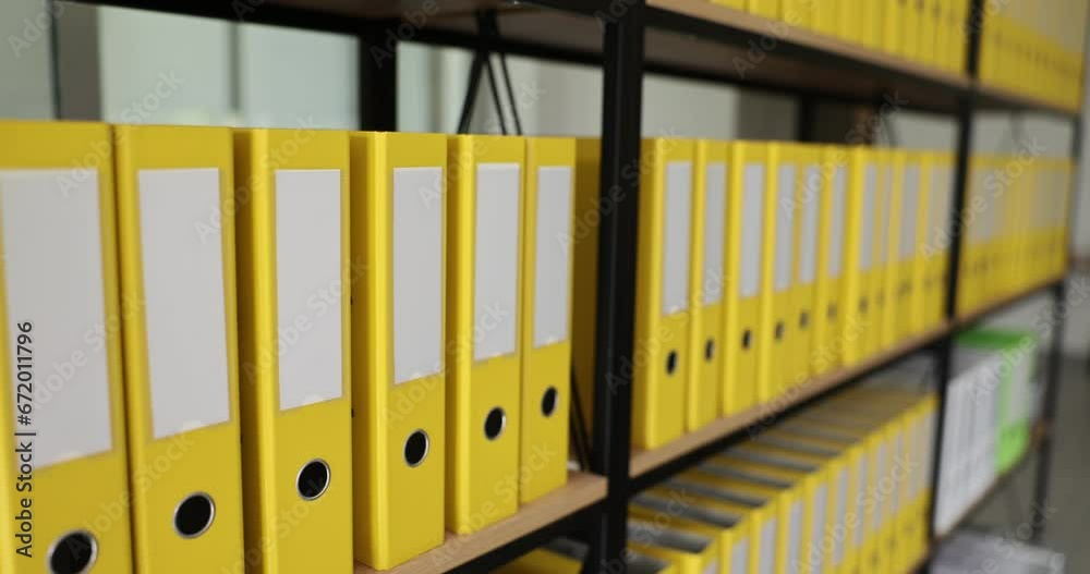 Yellow identical office folders on bookshelf in office