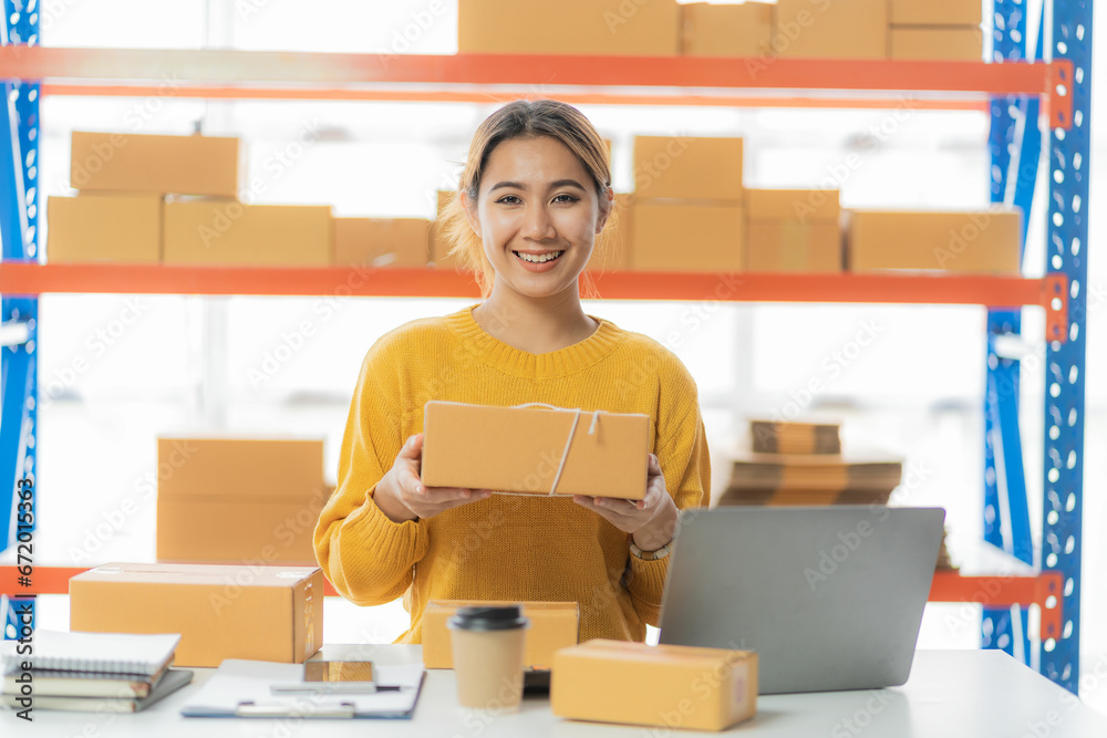 Beautiful Asian startup owner stays happily at home with packages on SME supply chain, purchasing, omnichannel purchasing or online selling ideas at home. Beautiful Asian startup owner stays happily at home with packages on SME supply chain, purchasing, omnichannel purchasing or online selling ideas at home.