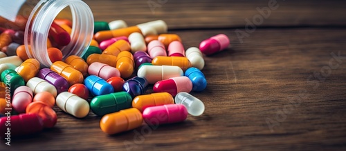 A vintage toned image displaying a close up view of a medical capsule pill or drug placed on a wooden background An abundance of vibrant medication and pills are present in the picture