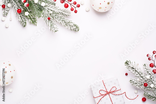 Christmas greeting card. Frame of Christmas decorations, gift and fir-tree. White background as copy space. Elegant classic style.