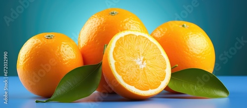 A freshly cut orange with its vibrant color and succulent flesh displayed against a backdrop of other oranges accompanied by their leafy adornments photo