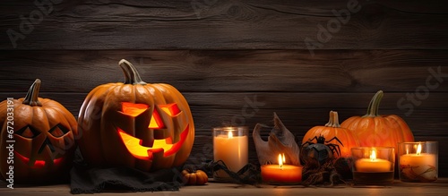 Getting ready for Halloween carving a pumpkin with a spooky face placing candles inside on a backdrop of rustic wood © 2rogan