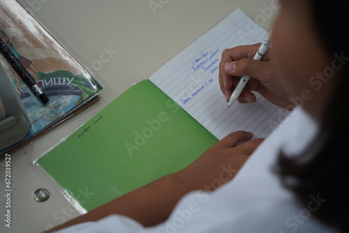 Almaty, Kazakhstan - 09.06.2023 : Schoolchildren write a dictation about autumn in class.