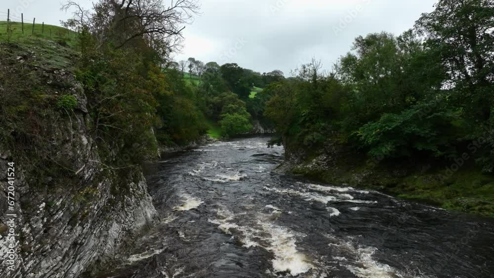 Slowly tracking past the river banks whilst a river flows underneath, Yorkshire, United Kingdom. Slowly tracking past the river banks whilst a river flows underneath, Yorkshire, United Kingdom.