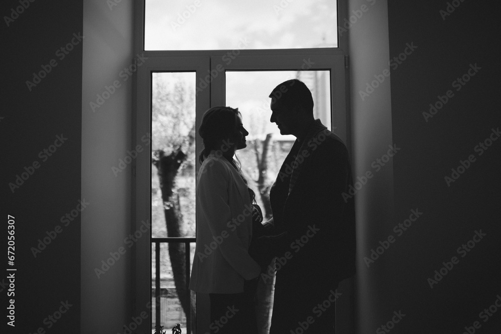 Young couple in love hug each other on the black background